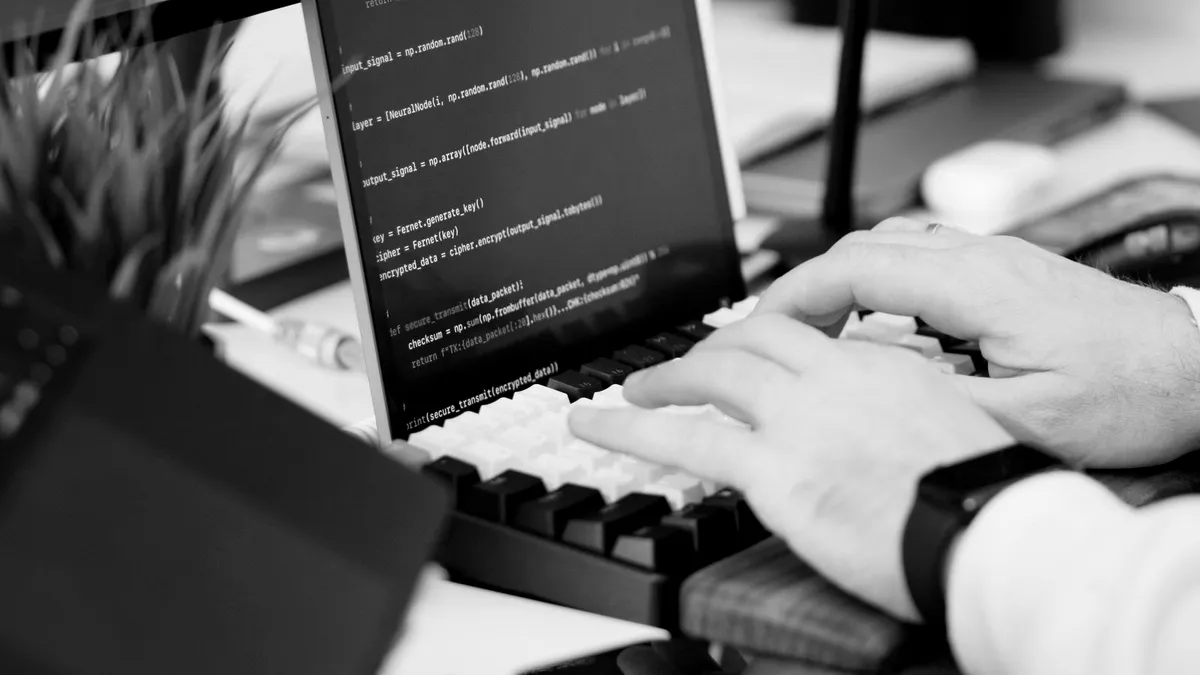 Developer typing code on a keyboard with a script on screen