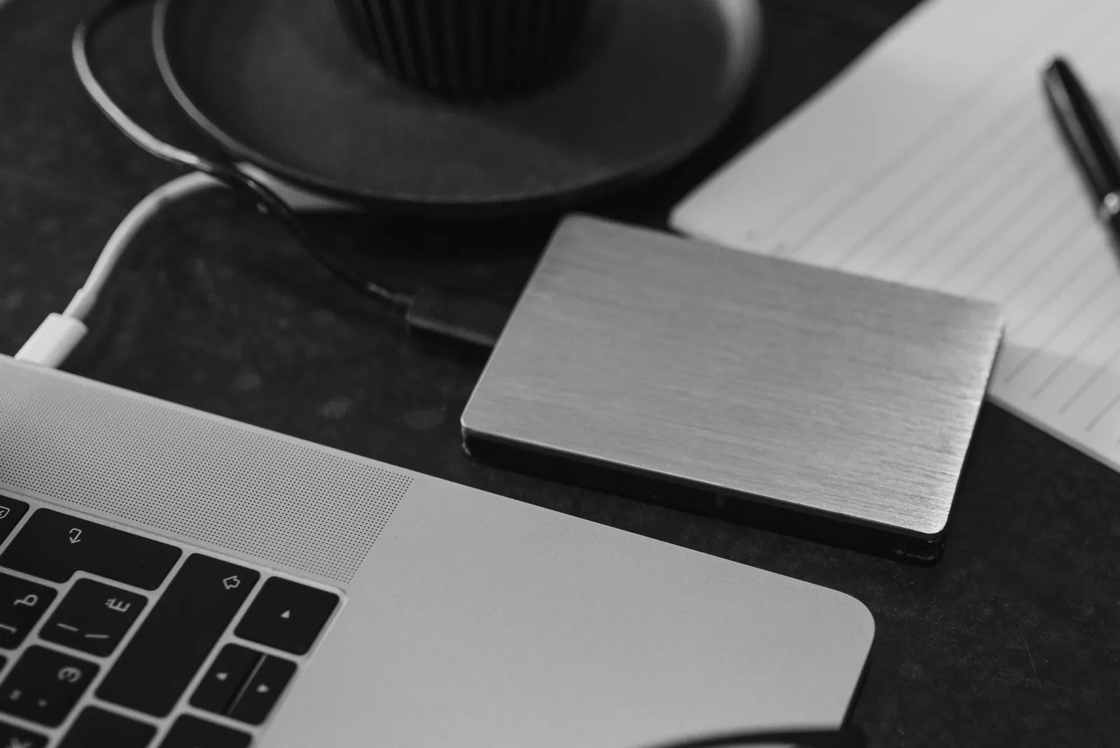 External hard drive connected to a laptop with a USB cable on a desk