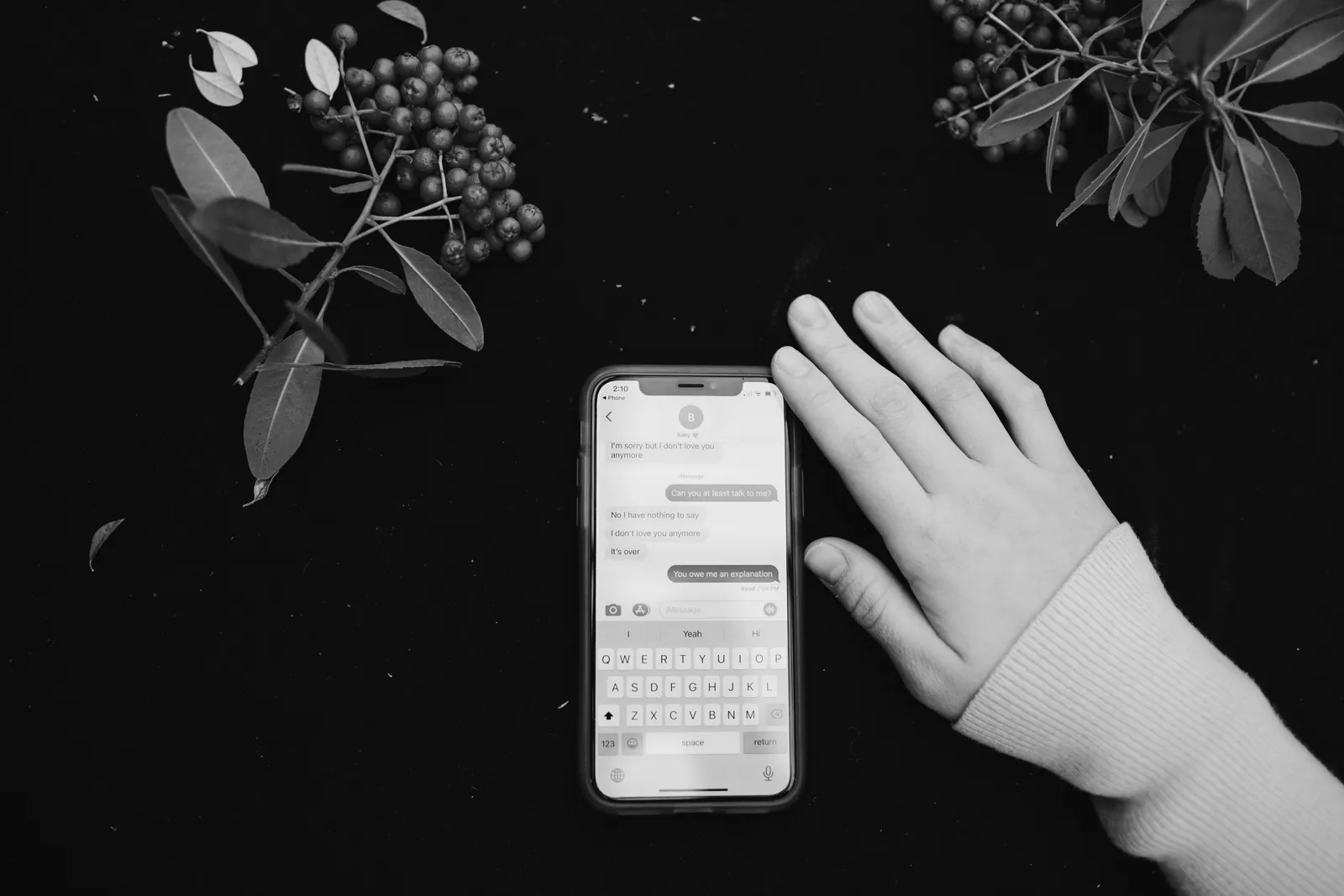Hand resting beside a smartphone showing a text conversation