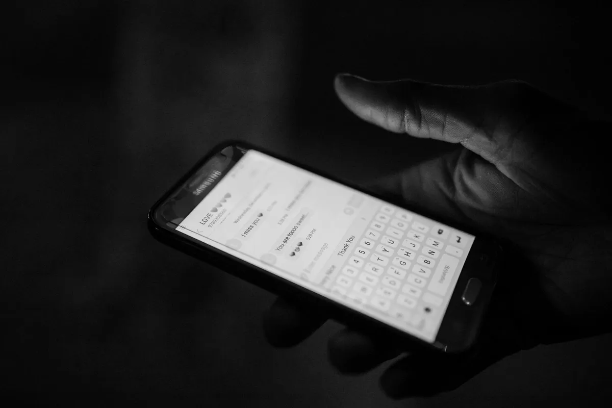 Hand typing a text message on a phone