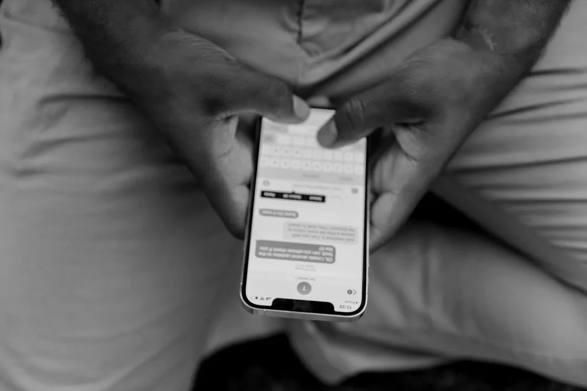 Hands holding a phone showing a text message thread