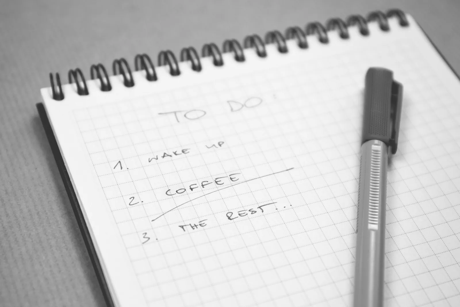 Handwritten checklist on graph paper beside a pen