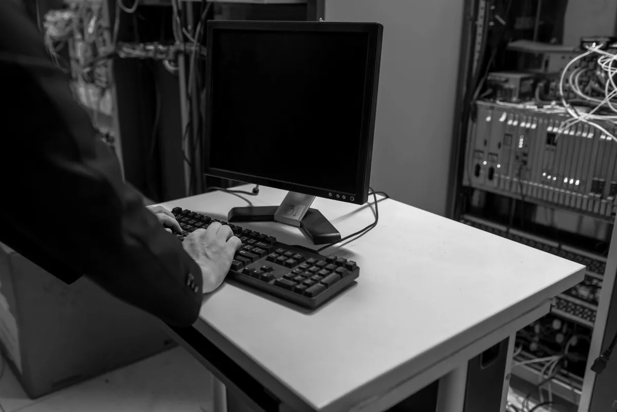 IT administrator typing at a computer in a server room