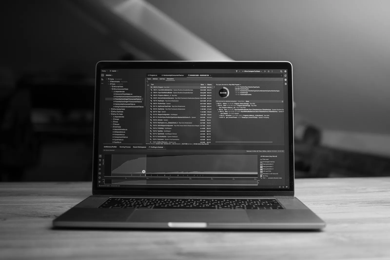 Laptop open on a wooden desk in a dimly lit workspace