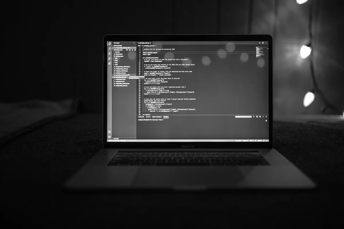 Laptop showing code in a dark room