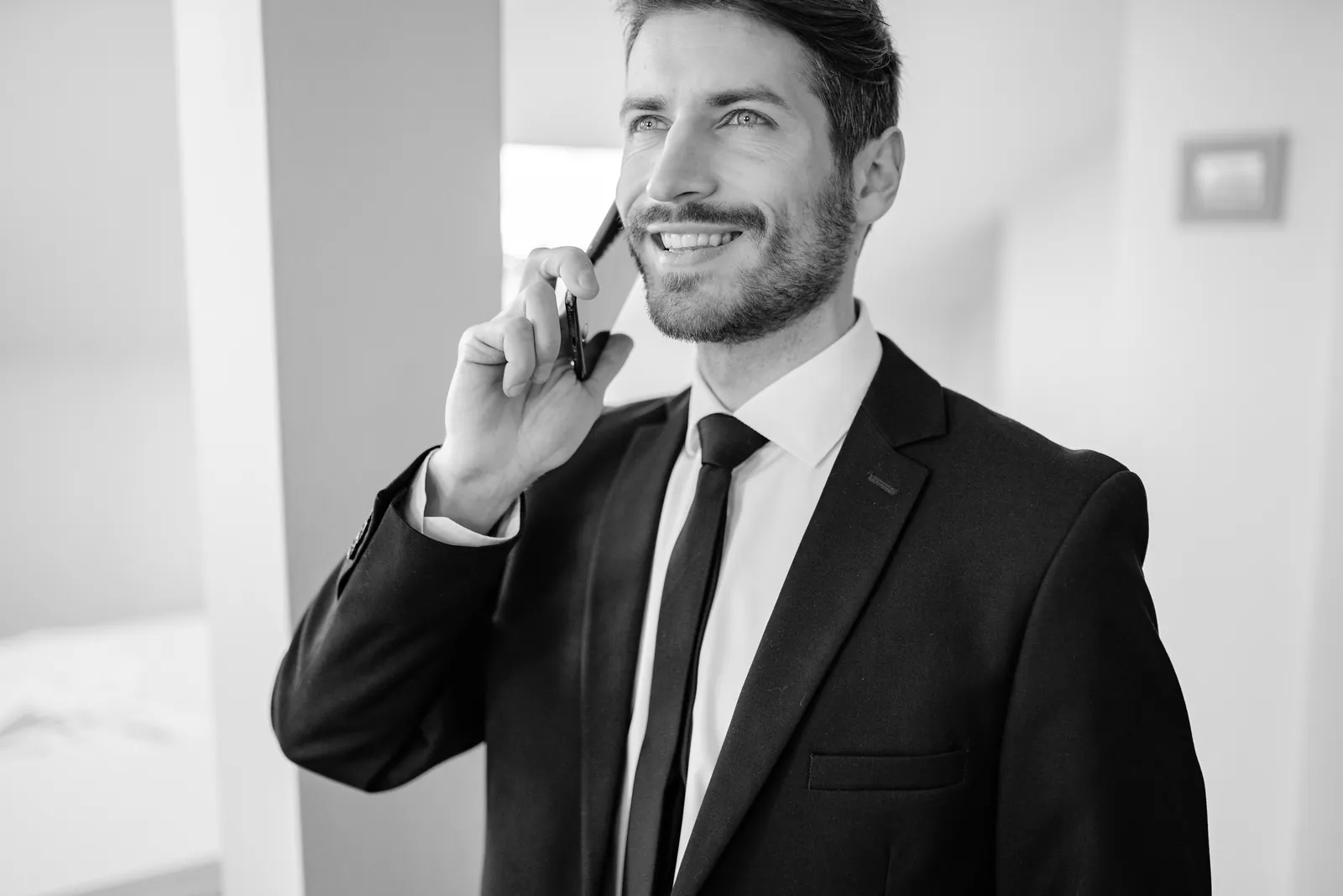 Man in a suit talking on a phone indoors