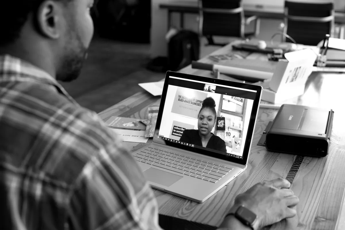 Man on a video call with a colleague from his office desk