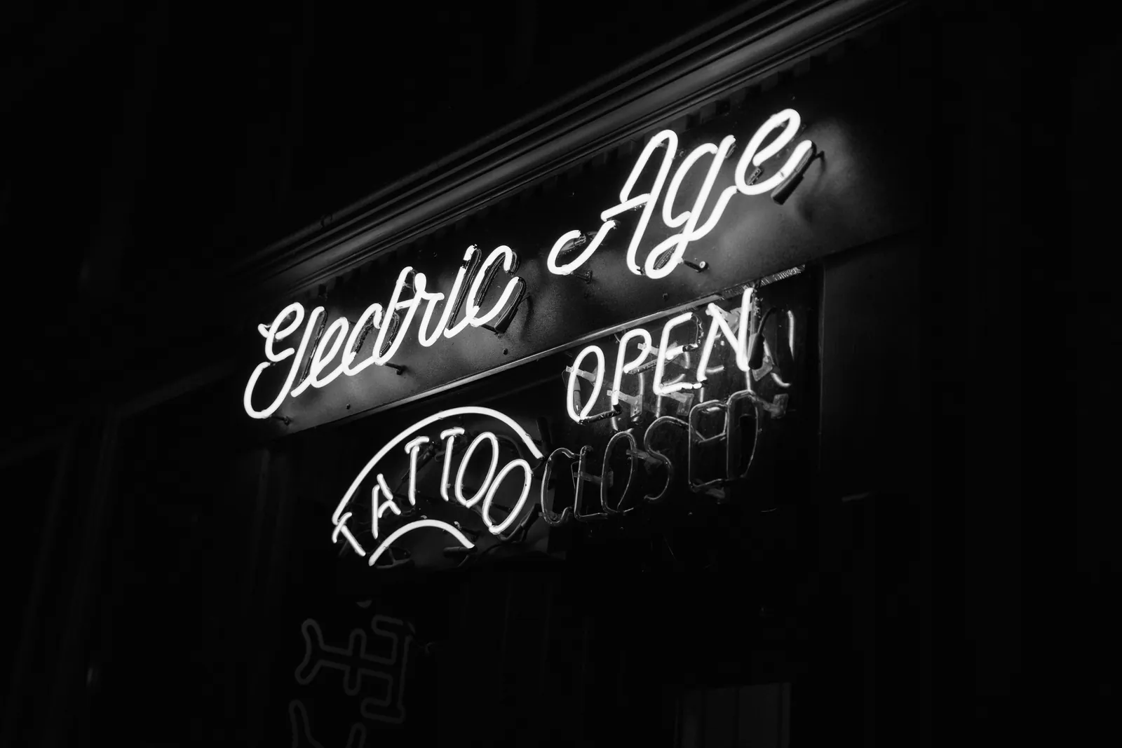 Neon shop signs glowing against a night sky