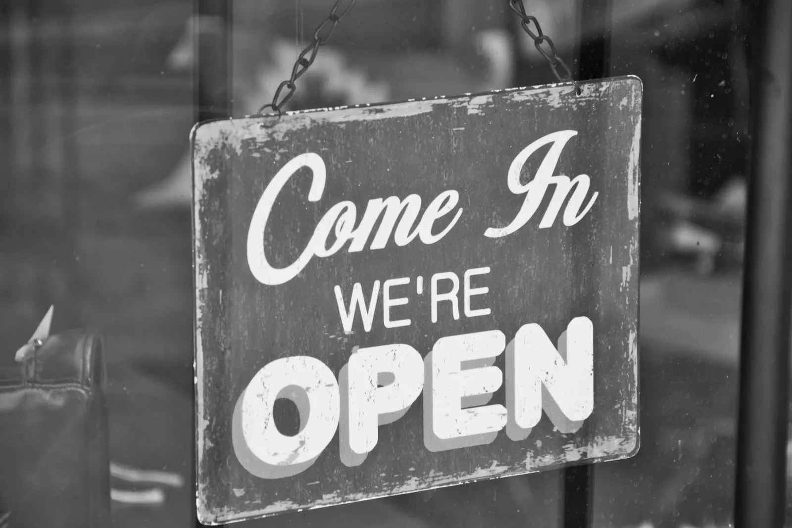 Open sign hanging on the glass door of a shop