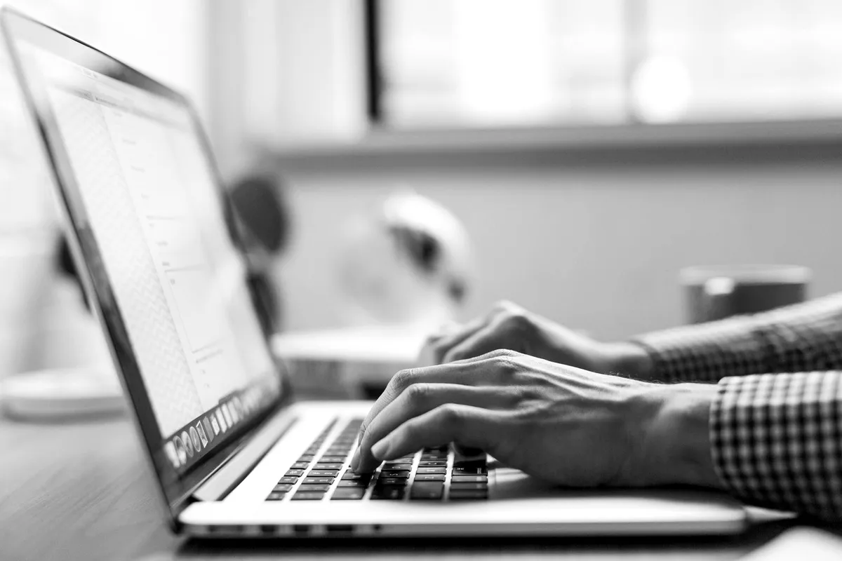 Person typing on a laptop with a web page open